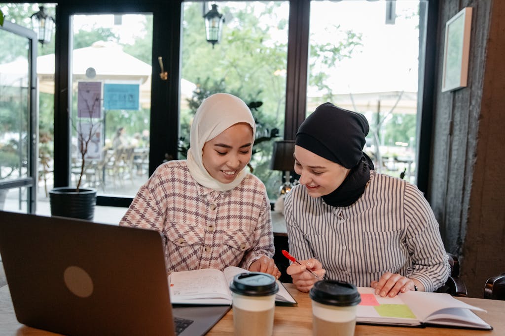 Smiling Woman Sitting and Studying at Cafe