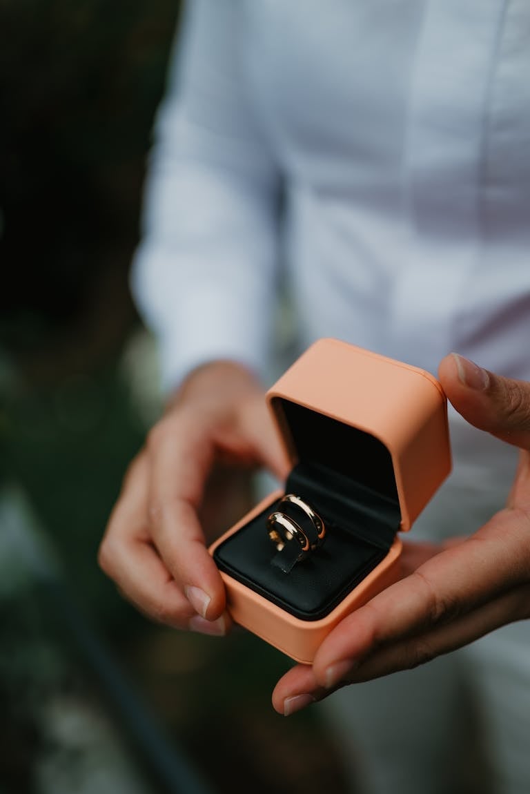 Elegant Ring in Box Held by Person in White Shirt