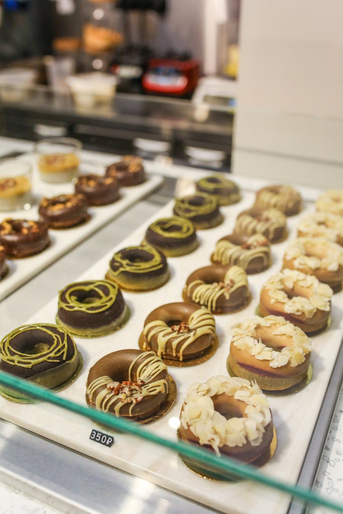 A tempting assortment of gourmet donuts displayed in a bakery. Perfect for food enthusiasts.